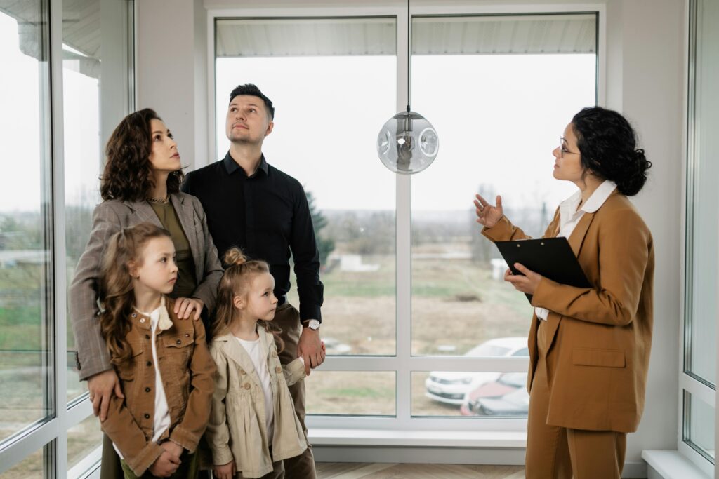 Services Family with children visits potential new home with a realtor inside modern house.